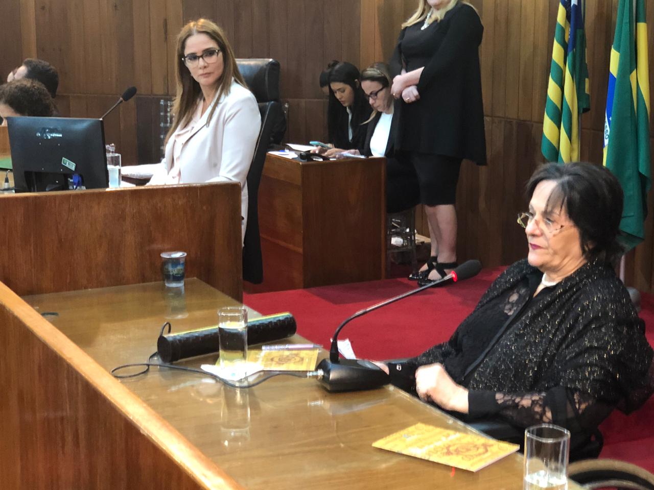 Maria da Penha, que ao discursar é observada por Lucy Soares