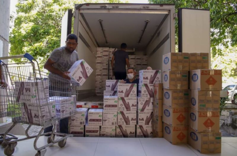 Trabalhadores descarregam carregamento de EPI's