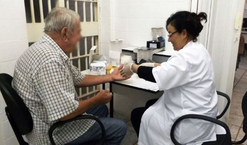 Preso idoso sendo atendido no ambiente penitenciário