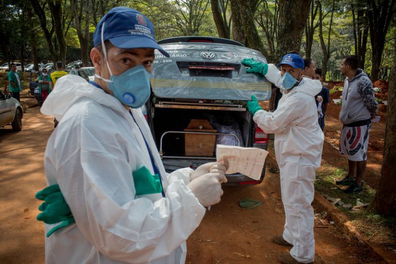 Sepultadores do Cemitério Vila Formosa, na Zona Leste de São Paulo, enterram pessoas que morreram com a suspeita de contaminação pelo novo coronavírus