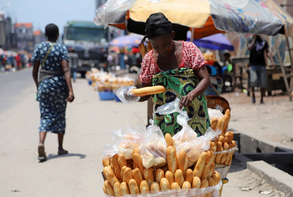 Mulher arruma mercadorias em um mercado de Kinshasa, capital da República Democrática do Congo, no dia 28 de março