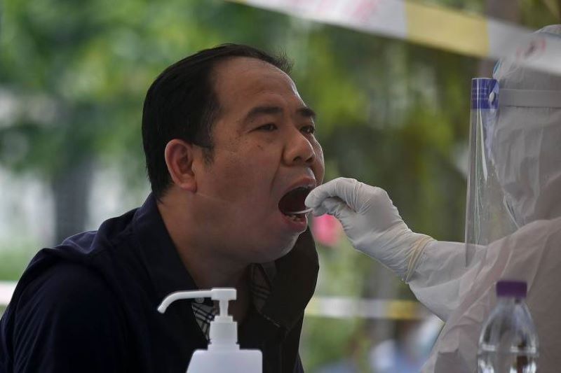 Profissional da saúde colhe amostra para teste de coronavírus em Pequim