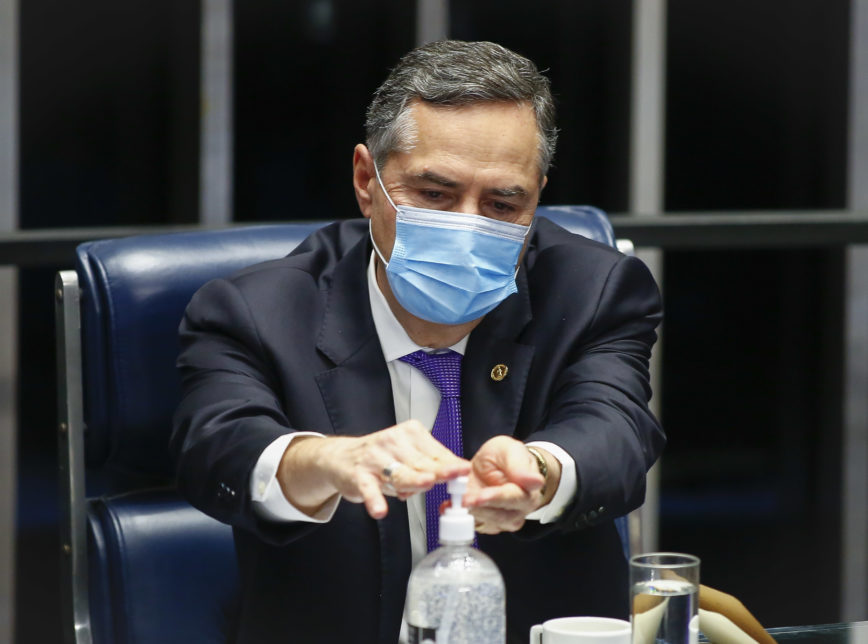 O presidente do TSE, Luis Roberto Barroso, higienizando as mãos no Congresso
