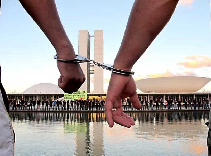 Agentes penitenciários colocam algemas nos punhos em frente ao Congresso Nacional para pedir a derrubada do veto ao projeto que concede porte de arma de fogo à categoria (Foto: Lucas Nanini/G1)
