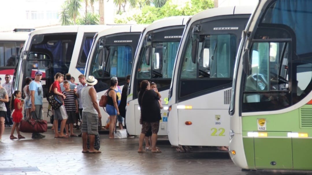 Terminal intermunicipal com passageiros embarcando nos ônibus