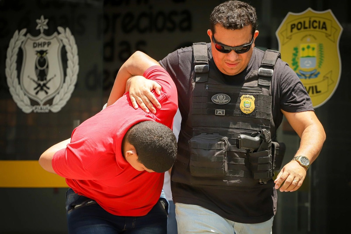 Marcos Rios sendo conduzido pelos policiais do DHPP